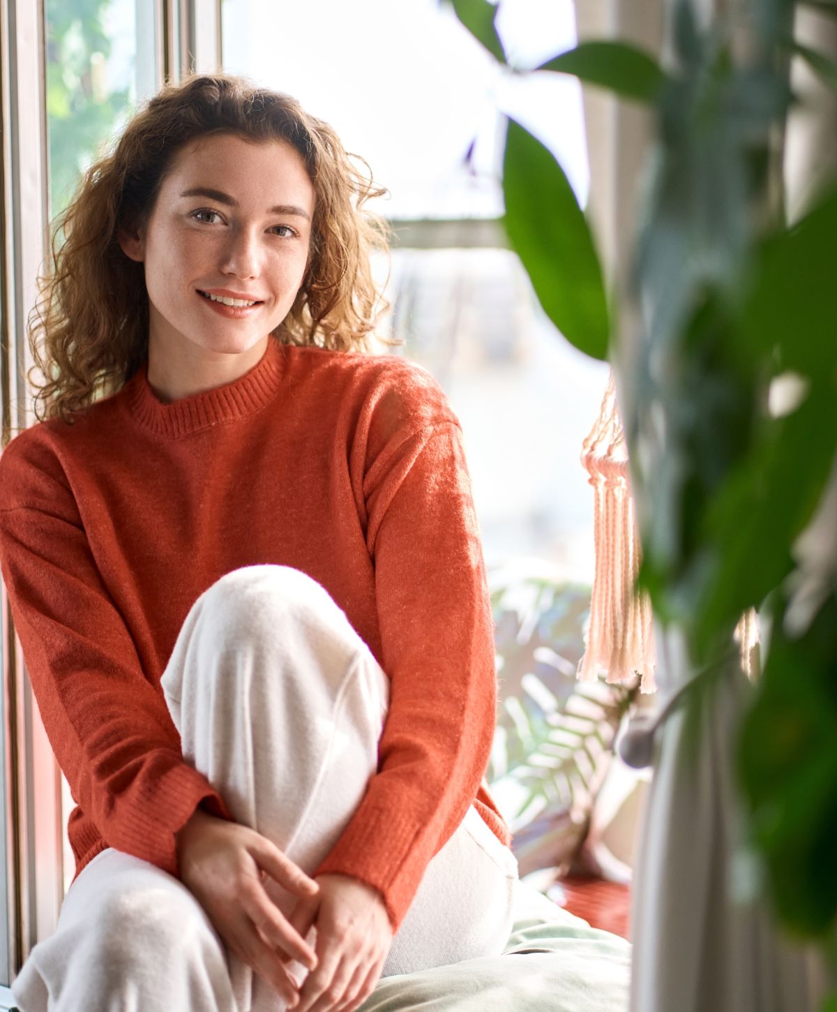 Alpharetta Body Contouring model sitting by window with plants.