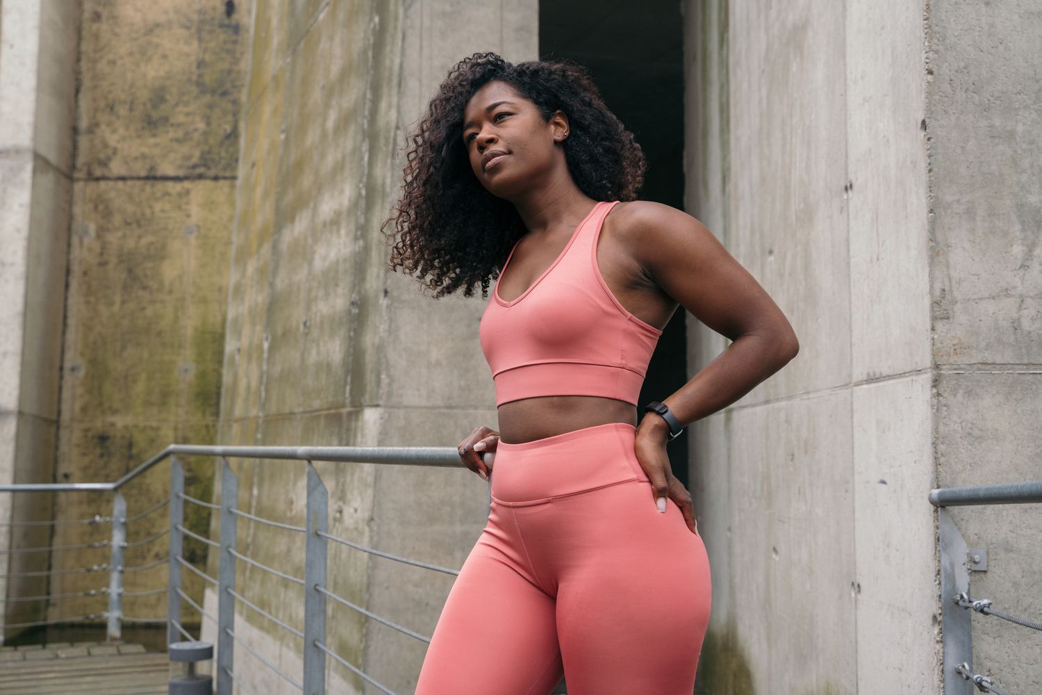 Alpharetta Women’s Weight Management model in activewear posing by concrete wall.