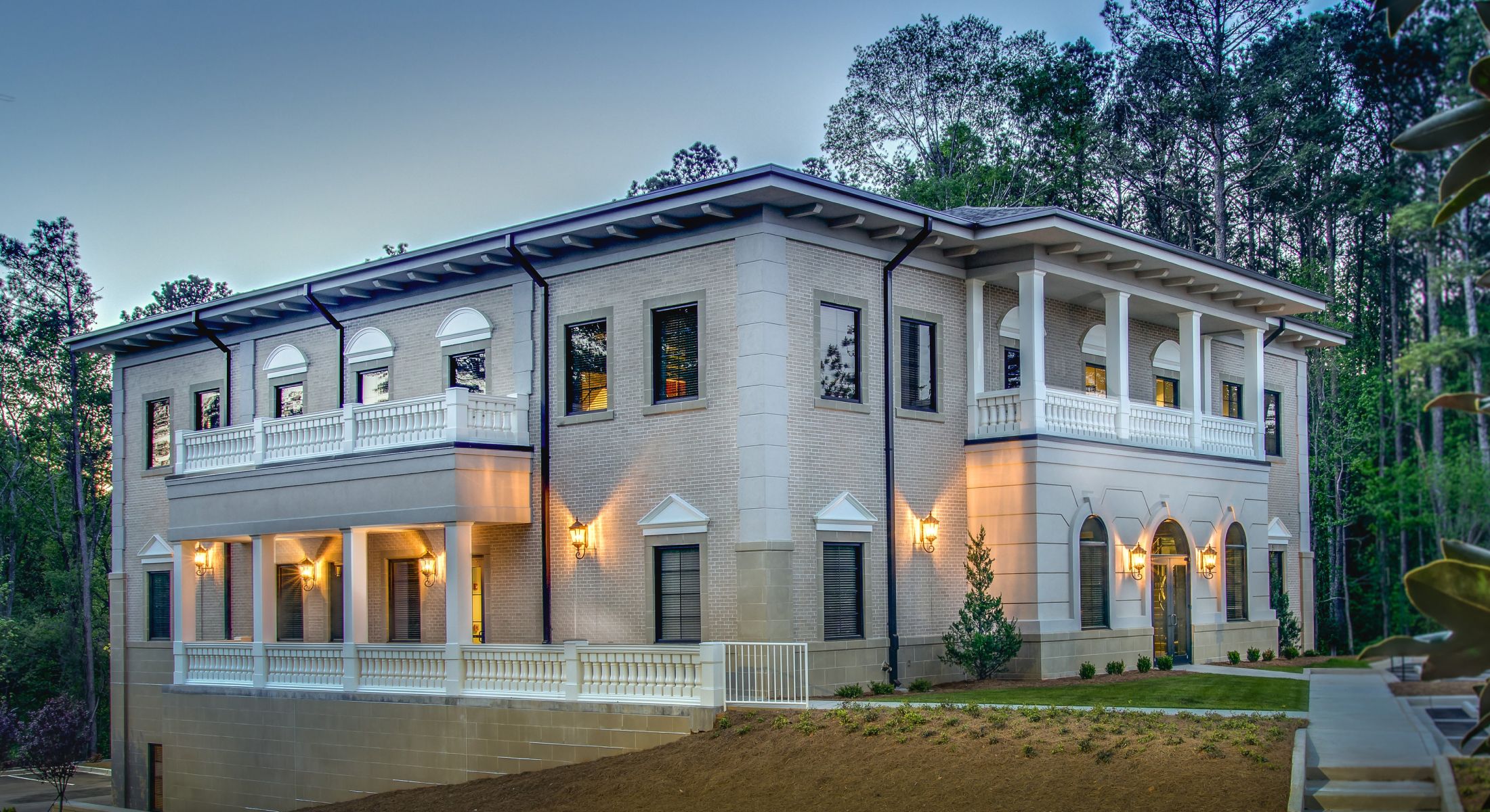 Elegant modern mansion surrounded by trees.